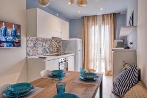 Il dispose d'une cuisine avec une table en bois et des plats bleus. dans l'établissement Katy Apartment, à Lido di Jesolo