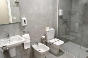 a bathroom with a toilet and a sink and a shower at Hotel Alda Estación Pontevedra in Pontevedra