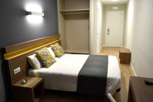 a bedroom with a large bed with pillows at Hotel Alda Estación Pontevedra in Pontevedra