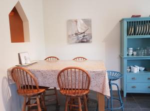 uma cozinha com uma mesa com cadeiras e um armário azul em Ethan Cottage em Killarney