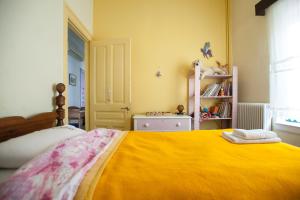 sypialnia z dużym łóżkiem i żółtym kocem w obiekcie Tis Mammis w Nauplionie