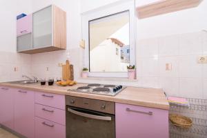a kitchen with a stove and a sink and a window at Apartments Marinera in Trogir +126 photos