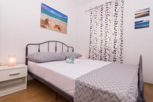 a small bedroom with a bed and a night stand at Apartments Marinera in Trogir