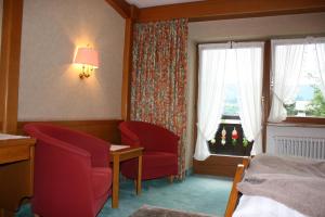 a room with a bed, chair, lamp and a window at Hotel Gasthof Adler in Oberstdorf