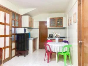 a kitchen with a table and chairs and a kitchen with a table and a kitchen at Lanzones Cabana in Mambajao