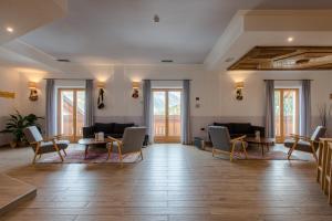 une grande chambre avec des chaises, des tables et des fenêtres dans l'établissement Hotel San Carlo, tra Bormio e Livigno, à Valdidentro