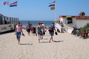 un groupe de personnes marchant sur la plage dans l'établissement Appartementen Natuurlijk, à Egmond aan Zee