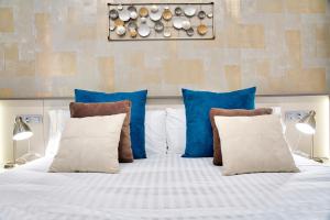 uma cama com almofadas azuis e brancas em Apartamentos Cava Baja em Madrid