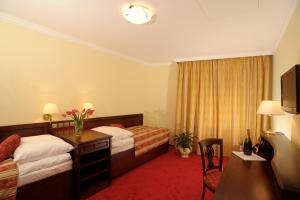 a hotel room with two beds and a desk at Hotel U Krále in Jičín +37 photos
