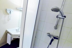 a shower with a shower head in a bathroom at Kyriad Beauvais Sud in Beauvais