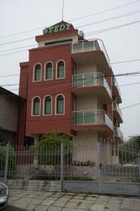 een rood gebouw met een bord erop bij Stedy Guest House in Chernomorets
