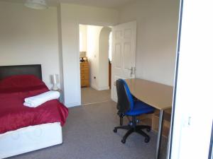 1 dormitorio con escritorio, 1 cama y 1 mesa en TEA in Liverpool - Private - Quiet - Ground Floor - En-suite - Walk-in-shower en Liverpool