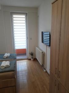 Habitación con cama, TV y puerta en Apartman TiM en Kruševac