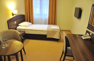 a hotel room with a bed and a table and chair at Hotel Dudek in Mniów