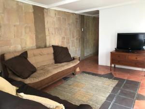 a living room with a couch and a flat screen tv at Contemporary Stay at Giraffe Cottage in Benoni