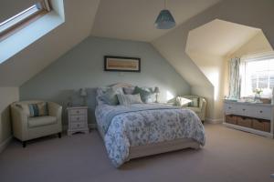 1 dormitorio con 1 cama y 1 silla en Pen Llyn Bed and Breakfast, en Dinas