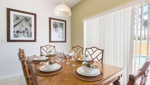 una sala da pranzo con tavolo in legno e sedie di Encantada Rose - a 4 bed townhouse near Disney a Kissimmee