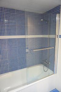 ein blau gefliestes Bad mit einer Dusche und einer Badewanne in der Unterkunft Happy Holiday Beach Home in Sitges + 10 Fotos