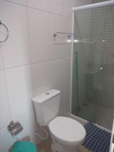 a white bathroom with a toilet and a shower at Pousada raios de sol indaia in Bertioga
