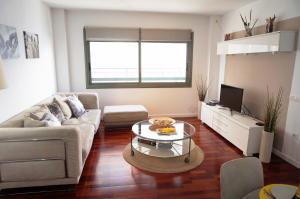 ein Wohnzimmer mit einer Couch und einem Couchtisch in der Unterkunft Happy Holiday Beach Home in Sitges