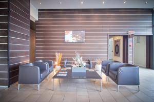 a waiting room with blue chairs and a table at iH Hotels Milano Gioia in Milan