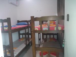 a room with three bunk beds in a room at Pousada raios de sol indaia in Bertioga