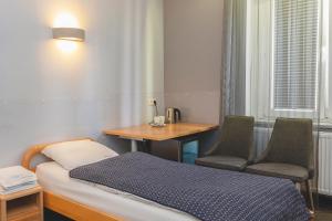 a room with a bed and a table and chairs at Pentagos in Poznań