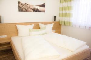 ヒパッハにあるApart Alpinのベッドルーム1室(白いシーツと枕のベッド1台付)