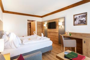 una camera d'albergo con letto e scrivania di Hotel Unterhof a Filzmoos