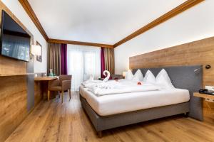 pokój hotelowy z dużym łóżkiem i biurkiem w obiekcie Hotel Unterhof w mieście Filzmoos