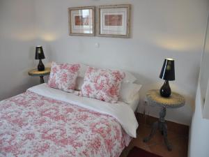 a bedroom with a bed and a lamp at Mil Reis in Vila Nova de Milfontes