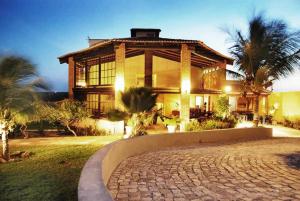 a large house with a brick driveway in front of it at Pousada Iguana in Canoa Quebrada