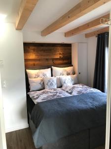 Schlafzimmer mit einem Bett mit einem Kopfteil aus Holz in der Unterkunft Ferienhaus am Dachsberg in Bad Saarow