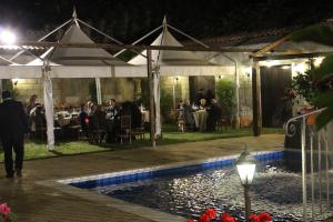 a wedding reception under a tent with a pool at night at B&B Montereale in Monreale