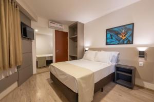 Säng eller sängar i ett rum på Via Garden Varginha Hotel