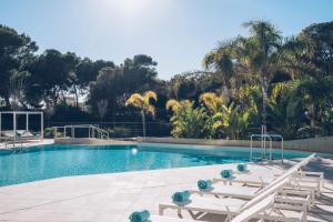 a swimming pool with lounge chairs next to a resort at Iberostar Selection Llaut Palma- Adults Only in Playa de Palma