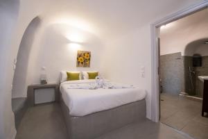 Un dormitorio con una gran cama blanca en una habitación. en Santo Blue Horizon Blue domes view, en Oia 18 fotos más