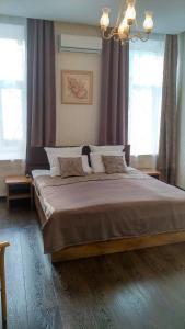 a bedroom with a large bed with purple curtains at Hotel Tverskaya 5 in Moscow