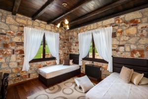 a bedroom with two beds and two windows at Sithonian Blue Royal Villa in Nikiti +38 photos