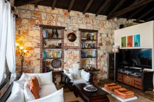 a living room with a stone wall at Sithonian Blue Royal Villa in Nikiti