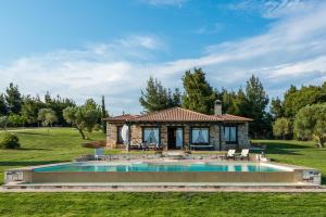 a house with a pool in the yard at Sithonian Blue Royal Villa in Nikiti