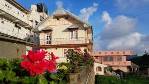 a pink and white building with flowers in front of it at ChandraSobana in Nuwara Eliya