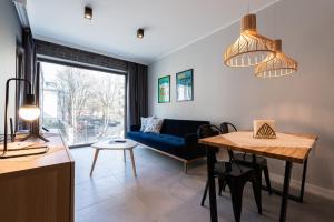 ein Wohnzimmer mit einem blauen Sofa und einem Tisch in der Unterkunft City Lights Rakowicka 15 in Krakau
