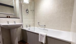 a bathroom with a sink and a bath tub next to a sink at The Fleece at Cirencester in Cirencester