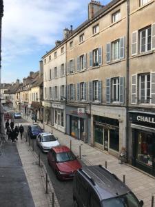 a city street with parked cars and buildings at Le Gîte d'Isa in Beaune