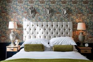 a bedroom with a large bed with a large headboard at The Fleece at Cirencester in Cirencester
