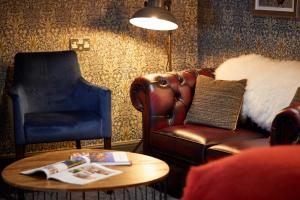 a living room with a couch and a chair and a table at The Fleece at Cirencester in Cirencester