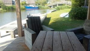 a wooden table and chairs sitting on a dock near the water at Wetterwillefriesland in Wommels +31 photos