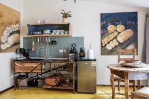 a kitchen with a refrigerator and a table and a painting at Central Cluj Apartments in Cluj-Napoca