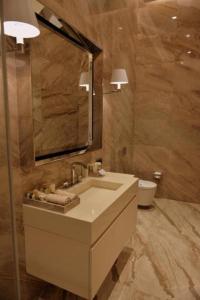 a bathroom with a sink and a mirror and a toilet at Kemer Country Hotel İstanbul in Istanbul